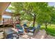 Backyard patio seating with an adjacent deck, lawn, and play structure at 12671 Meadow Bridge Way, Parker, CO 80134