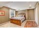 Cozy bedroom with wooden bed frame, natural light, and hardwood floors at 12671 Meadow Bridge Way, Parker, CO 80134