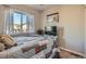 Comfortable bedroom with a quilt bed cover, large window with curtains, and neutral walls at 11250 Florence St # 22B, Commerce City, CO 80640
