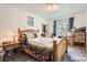 Cozy bedroom featuring a wood bed frame with neutral walls and a light-filled window at 1002 S Miller St, Lakewood, CO 80226