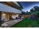 Spacious backyard with patio seating, playground set, and lush green lawn at 5611 W Bates Ave, Denver, CO 80227
