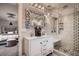 Bathroom features a modern vanity, intricate mirror, and glass enclosed shower with a built in seat at 5611 W Bates Ave, Denver, CO 80227
