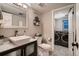 Bathroom featuring modern vanity with vessel sink, toilet, and laundry room access at 5611 W Bates Ave, Denver, CO 80227