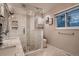Bathroom with glass enclosed shower, updated tile, and marble topped vanity at 5611 W Bates Ave, Denver, CO 80227