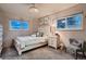 Charming bedroom features a decorative chandelier and ample natural light from the windows at 5611 W Bates Ave, Denver, CO 80227