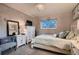 Comfortable bedroom showcasing a dresser with television, relaxing chair, and large window at 5611 W Bates Ave, Denver, CO 80227