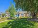 Charming home with a well-manicured lawn, mature trees, and inviting front porch seating at 3018 S Cherry Way, Denver, CO 80222