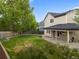 Lush backyard featuring a well-maintained lawn, fire pit, covered patio, and garden beds along the fence line at 9898 Tourmaline Ct, Parker, CO 80134