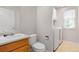 Bathroom with a single sink vanity, toilet, and a washer and dryer in a bright naturally lit space at 9898 Tourmaline Ct, Parker, CO 80134