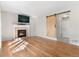 Bright living room featuring hardwood floors, fireplace, barn door, and neutral wall color at 9898 Tourmaline Ct, Parker, CO 80134