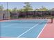 Well-maintained community tennis court with a blue and red surface, and black netting at 9898 Tourmaline Ct, Parker, CO 80134
