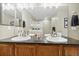 Bright bathroom featuring double sinks, granite counters, and a large well-lit mirror at 1761 S Buchanan Cir, Aurora, CO 80018