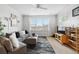 Cozy living room features a large window, comfortable seating, and a ceiling fan at 1761 S Buchanan Cir, Aurora, CO 80018