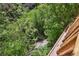 Scenic backyard view with lush greenery, mature trees, and a charming stream running through the property at 1024 Cottonwood Cir, Golden, CO 80401