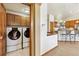 Convenient laundry room with washer, dryer, and cabinetry, leading into the open kitchen area at 1024 Cottonwood Cir, Golden, CO 80401
