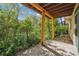 Outdoor patio with wooden support beams, overlooking a private lush backyard and stone landscaping at 1024 Cottonwood Cir, Golden, CO 80401