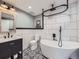 Modern bathroom featuring a freestanding tub, sleek vanity, and stylish black and white tiled floor at 8739 Culebra St, Arvada, CO 80007