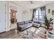 Cozy living room with a gray sofa, colorful rug, large window and an open entry at 8739 Culebra St, Arvada, CO 80007