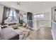 Open concept living room with a gray sofa, colorful rug, large window and brick fireplace at 8739 Culebra St, Arvada, CO 80007