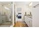 Bright bathroom featuring double vanity with granite countertop, a glass shower, and wood flooring at 5227 Lake Port Ave, Longmont, CO 80504