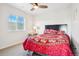 Bedroom featuring ceiling fan, window, and a bed with decorative red patterned comforter at 5227 Lake Port Ave, Longmont, CO 80504