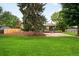 Spacious backyard with lush green grass and a large patio area at 655 Cree Cir, Boulder, CO 80303