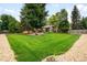 Lush backyard with sprawling green lawn, mature trees, and a charming single-Gathering home at 655 Cree Cir, Boulder, CO 80303