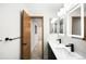 Bathroom showcasing double sinks, modern lighting, and a door that enters into the hall at 655 Cree Cir, Boulder, CO 80303