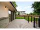 Inviting back deck area with sleek black railing, a brick wall and an adjacent well-kept lawn at 655 Cree Cir, Boulder, CO 80303