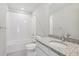 Bathroom features a shower-tub combo, white tile surround, and granite countertop sink at 7245 Goldbloom Ln, Littleton, CO 80125