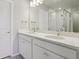 Bathroom features a double-sink vanity, white cabinets, granite countertops, and modern lighting at 7245 Goldbloom Ln, Littleton, CO 80125