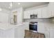 Well-appointed kitchen featuring white cabinets, stainless steel appliances, and a gray backsplash at 7245 Goldbloom Ln, Littleton, CO 80125