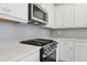 Close-up of a kitchen stove and overhead microwave at 7245 Goldbloom Ln, Littleton, CO 80125