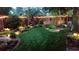 Backyard with lush green lawn and decorative string lights along the fence at 1572 Leyden St, Denver, CO 80220