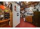 Basement storage area with exposed ceiling, red floors, and an organized tool rack at 1572 Leyden St, Denver, CO 80220