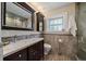 Bathroom featuring tile flooring, a marble sink vanity and a large mirror with lighting at 1572 Leyden St, Denver, CO 80220