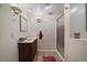 Bright bathroom featuring a vanity with marble counter, tiled floors and a glass-enclosed shower at 1572 Leyden St, Denver, CO 80220