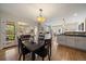 Open dining area with dark wood table, chairs, and lighting open to the kitchen at 1572 Leyden St, Denver, CO 80220