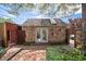 Brick outbuilding with double doors and skylight, surrounded by greenery and a paved patio at 1572 Leyden St, Denver, CO 80220