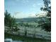 Picturesque backyard view featuring a white fence overlooking rolling hills and lush greenery at 3378 Shoveler Trl, Castle Rock, CO 80104