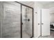Modern tiled shower with a glass door, a built-in shelf, and stylish fixtures at 3378 Shoveler Trl, Castle Rock, CO 80104
