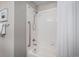 Clean bathroom with white tiled tub and shower featuring chrome fixtures and shower safety bar at 3378 Shoveler Trl, Castle Rock, CO 80104