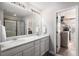 Bright bathroom with double sinks, a large mirror, and a glass-enclosed shower stall at 3378 Shoveler Trl, Castle Rock, CO 80104