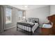 Comfortable bedroom with a black metal bed frame, bright windows, and neutral-colored carpet at 3378 Shoveler Trl, Castle Rock, CO 80104