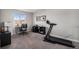 Bright bedroom with a treadmill, a desk with a view, and neutral-colored walls and carpet at 3378 Shoveler Trl, Castle Rock, CO 80104