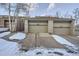 Townhome exterior featuring a two-car garage with snow in the driveway at 748 Ridgeside Dr, Golden, CO 80401