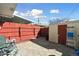 Backyard area with a stone patio, a shed, and a red fence, creating a private outdoor space at 1009 Milky Way, Thornton, CO 80260