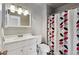 Charming bathroom featuring a modern vanity, toilet, and shower with a patterned curtain at 1009 Milky Way, Thornton, CO 80260