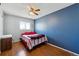 This bedroom features hardwood floors, a ceiling fan, and a window with natural light at 1009 Milky Way, Thornton, CO 80260