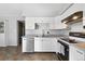 Well-lit kitchen featuring stainless steel dishwasher, double sink, and white cabinetry for ample storage at 1009 Milky Way, Thornton, CO 80260